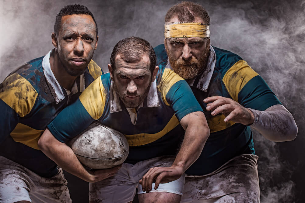 Bild zeigt drei Rugby Spieler, die in die Kamera schauen und hoffen, dass du durch den Lottoland Rugby Guide auf das richtige Team wettest.