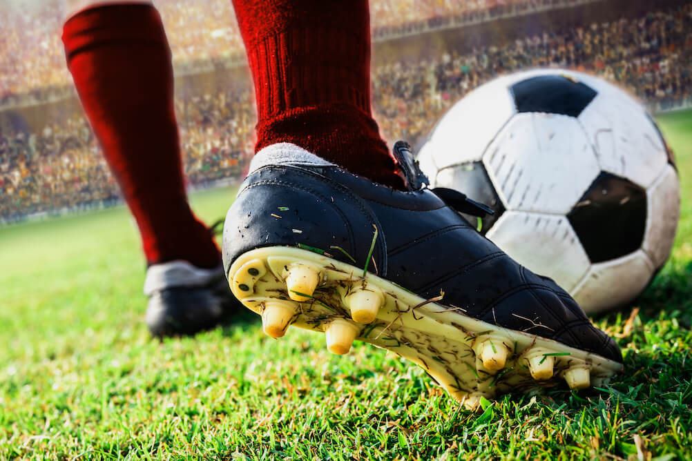 Nahaufnahme eines Balls kurz vor dem Schuss, erfahre im Lottoland, wie man auf Fußball wettet.